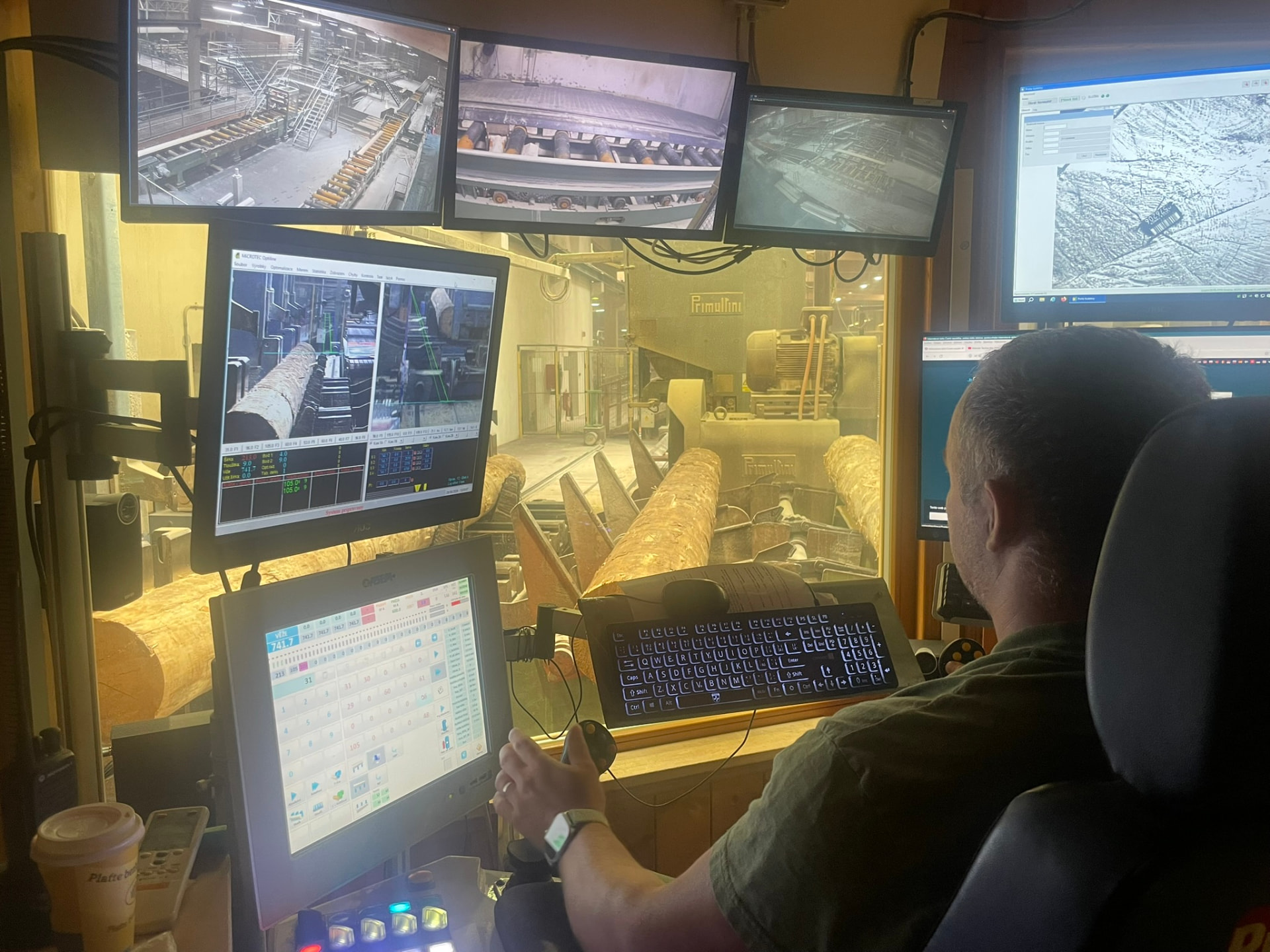 Operátor sleduje data o pořezu na monitorech v kabině pásové pily